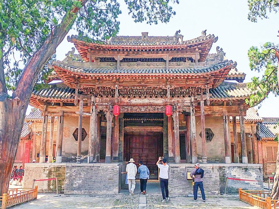游客在汾城镇城隍庙领略古建筑魅力。